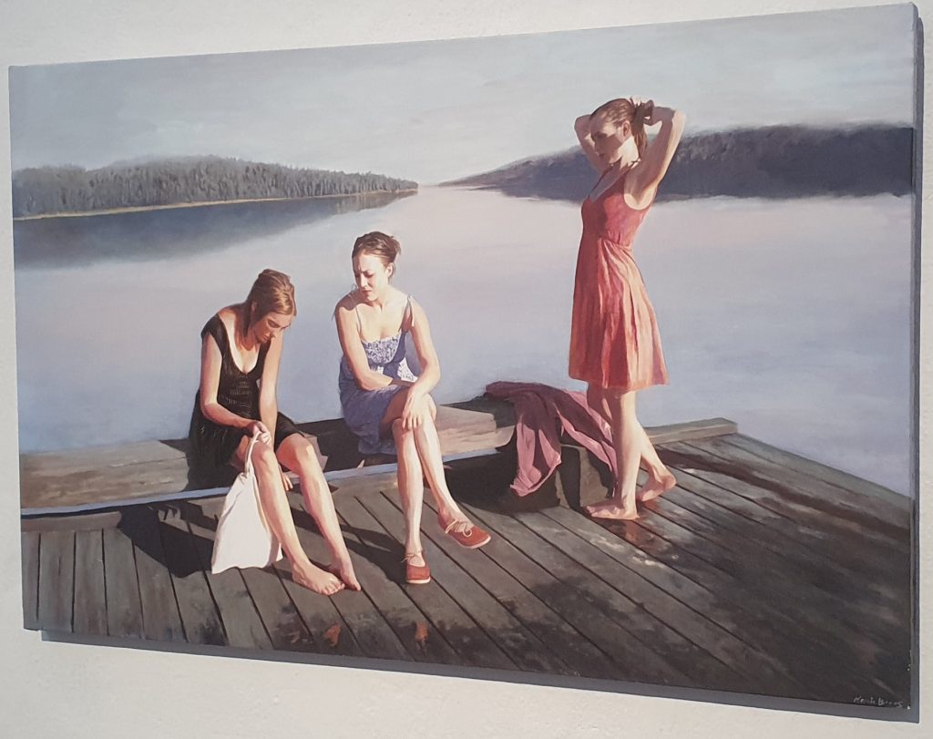 A painting showing three women on a dock on a lake. They have just been in for a swim.